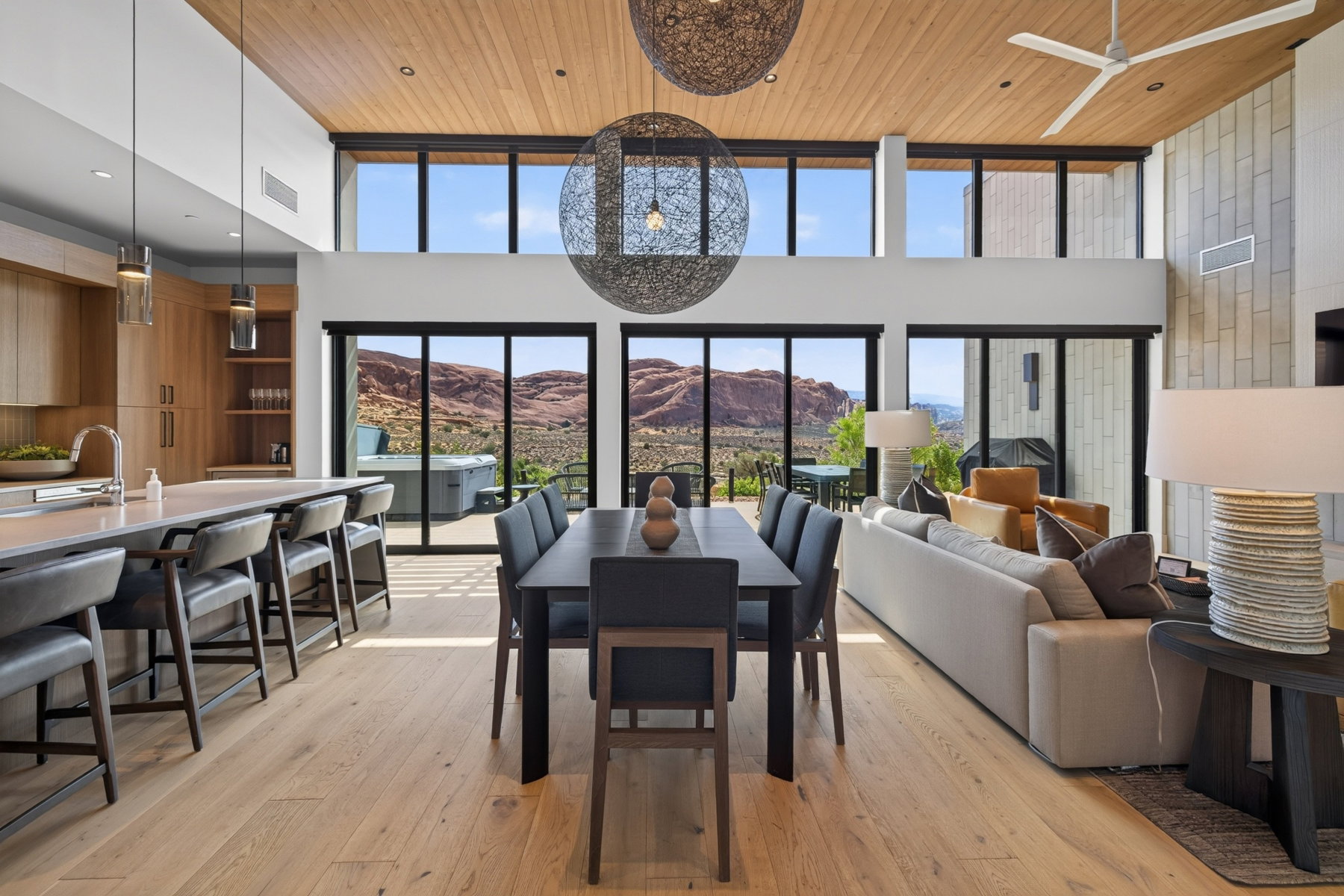 Open-concept living area featuring wood-finish flooring, a wood-paneled ceiling, and expansive windows