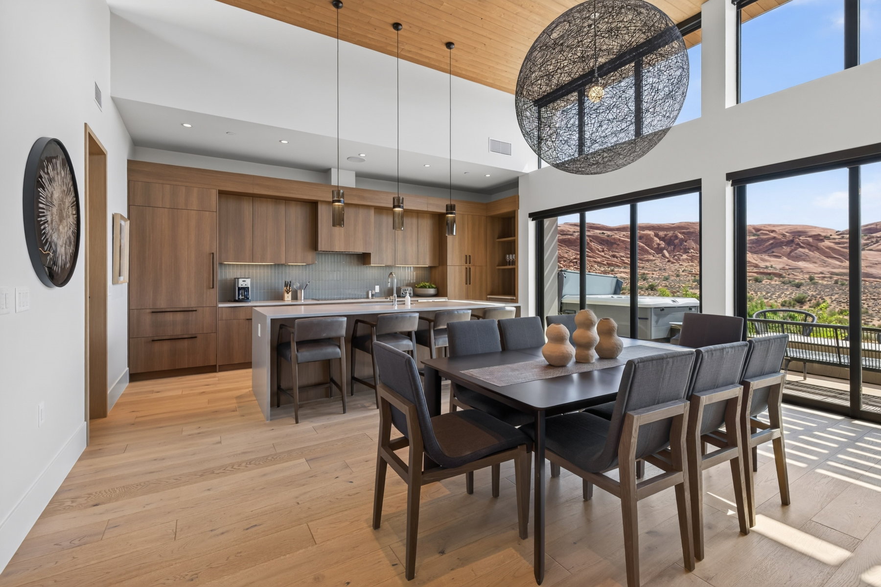 Open-concept living space with expansive floor-to-ceiling windows, showcasing a desert landscape