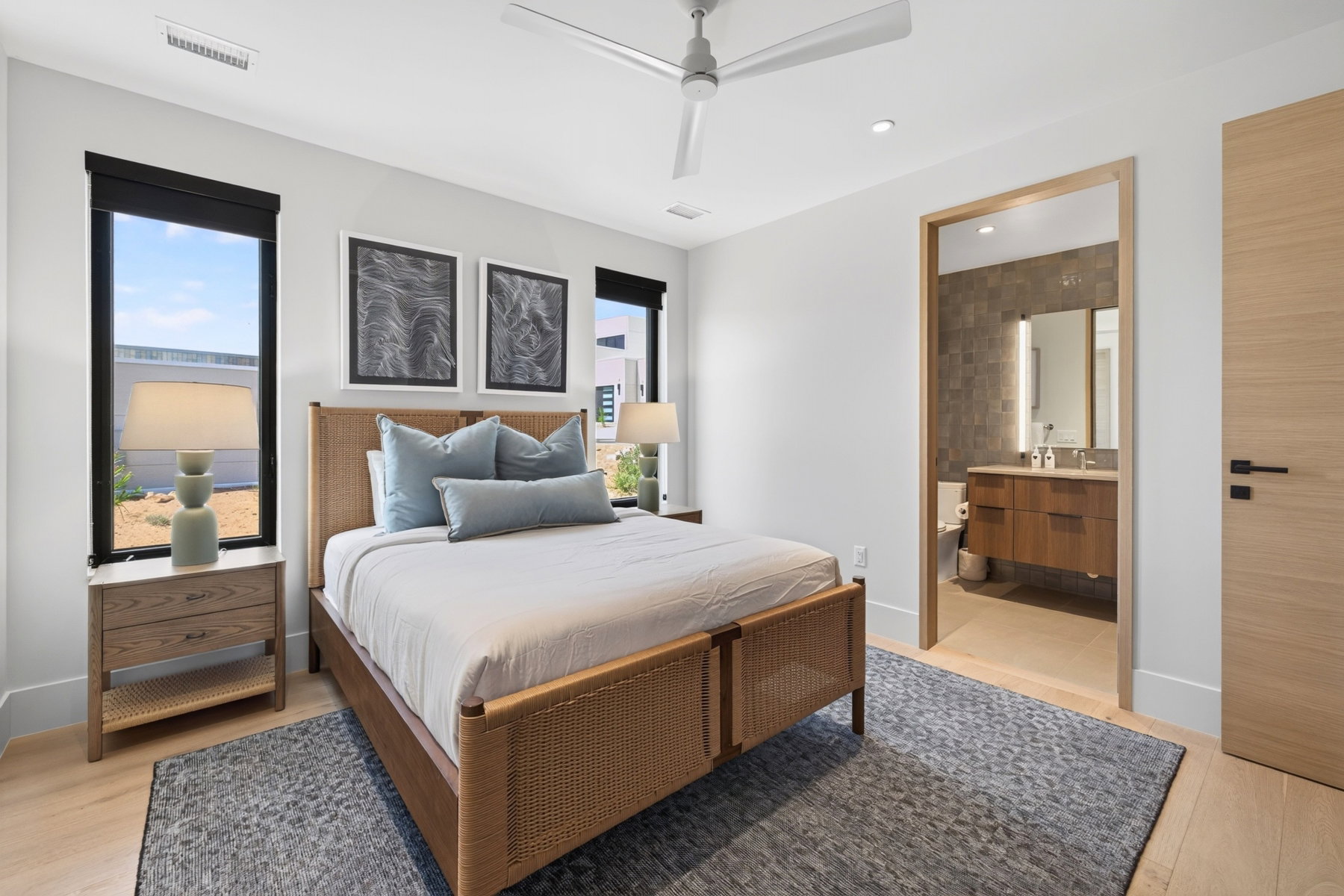Light wood-finish flooring with an area rug, white walls, and recessed lighting