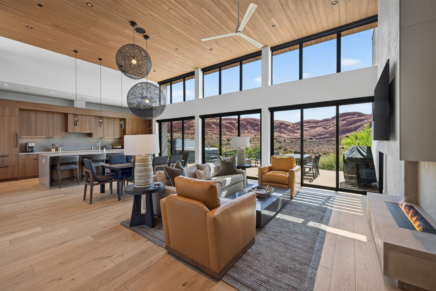 Open-concept living space featuring wood-finish flooring, a wood-paneled ceiling, and a modern linear fireplace