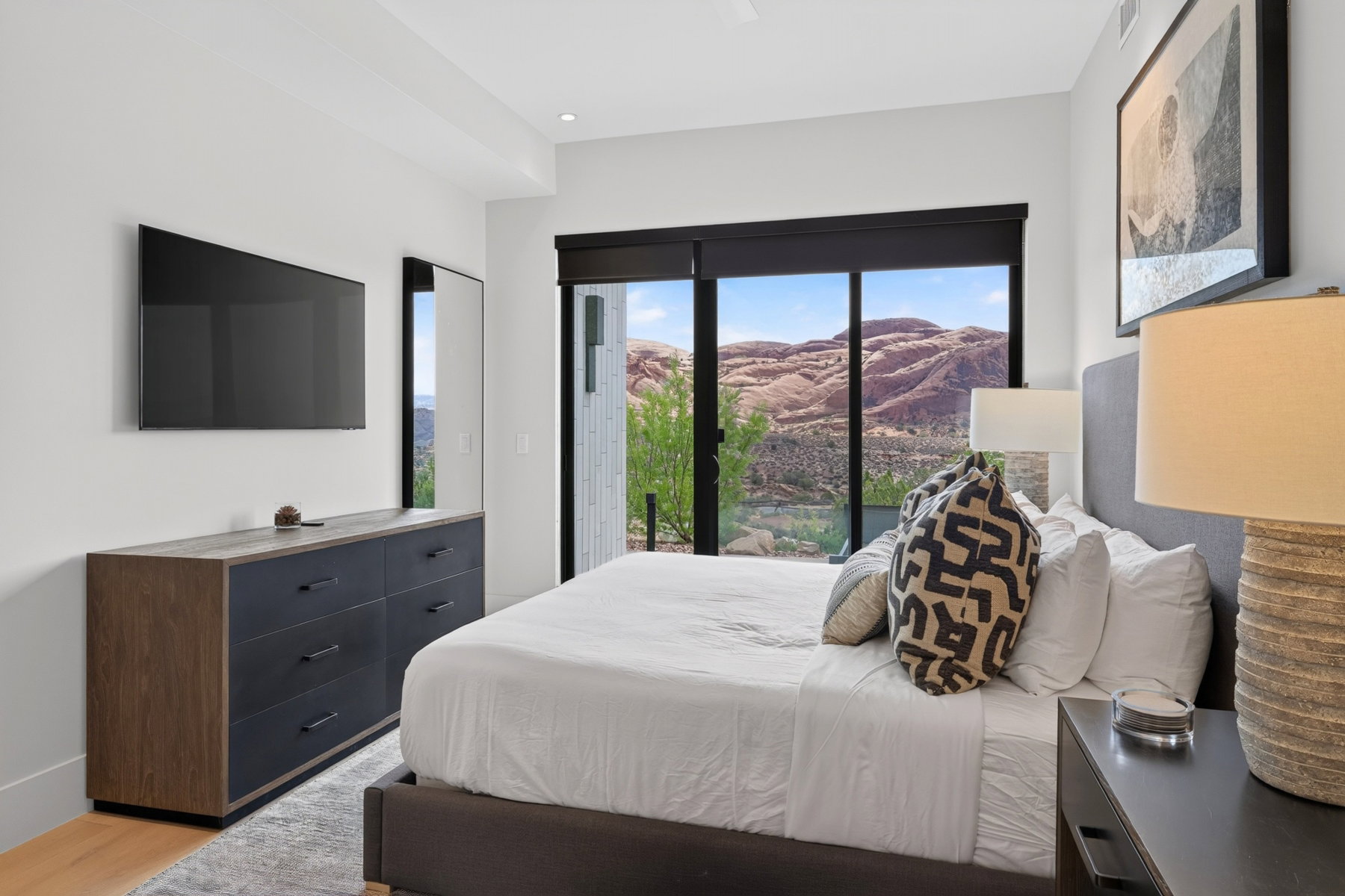 Expansive sliding glass doors reveal a rugged mountain backdrop