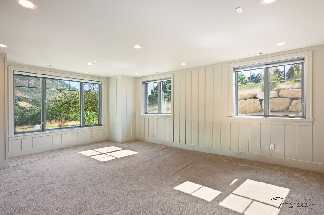 Spacious room featuring board and batten wainscoting, recessed lighting, and light-toned carpeting