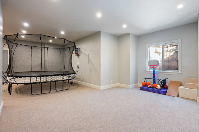 Spacious recreation room featuring recessed lighting, light gray wall paint, and neutral carpeting