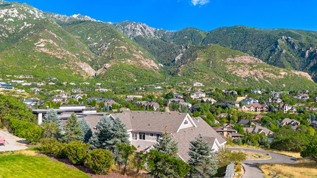 Mountain backdrop showcasing a residential area with varied rooflines and a mix of mature trees and landscaping