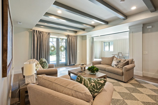 Spacious living area featuring exposed ceiling beams and recessed lighting