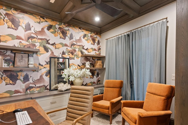Office space featuring decorative wall covering, wood-finish coffered ceiling with recessed lighting, built-in cabinetry with a light-toned countertop, and floating wood-finish shelving