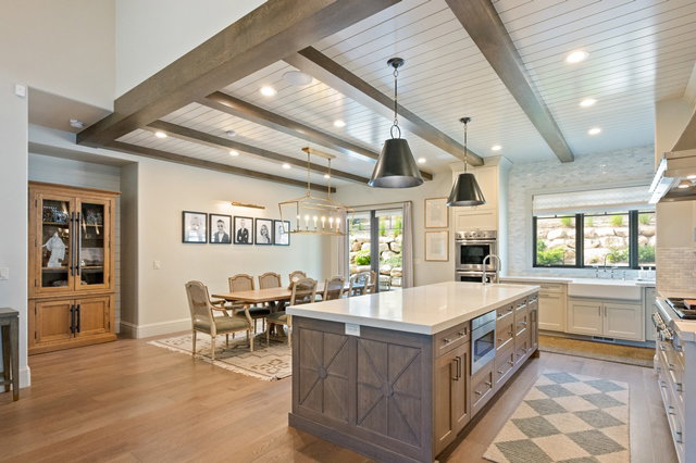 Spacious kitchen and dining area featuring wood-finish flooring, a coffered ceiling with exposed beams, and recessed lighting