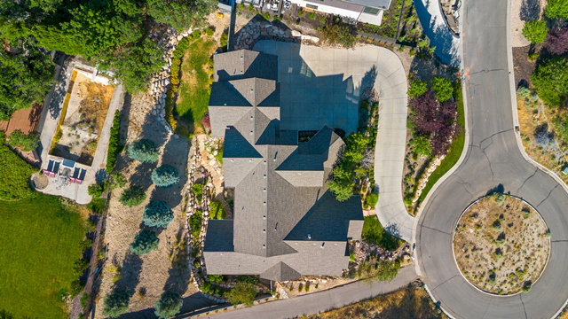 Expansive property featuring a multi-gabled roofline, substantial paved driveway, and varied landscaping