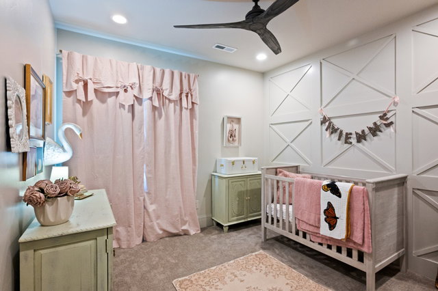 Recessed lighting illuminates a room featuring an accent wall with decorative paneling