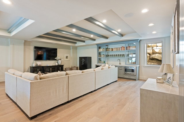 Spacious room featuring light wood-finish flooring, recessed lighting, and a beamed ceiling