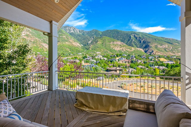 Expansive outdoor deck featuring wood-finish flooring and a white railing system