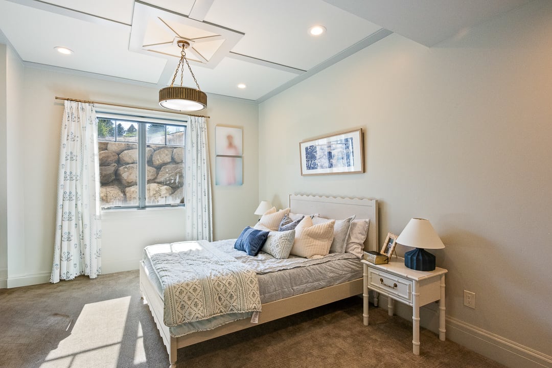 Bedroom featuring a tray ceiling with a central pendant light fixture, recessed lighting, and neutral wall tones