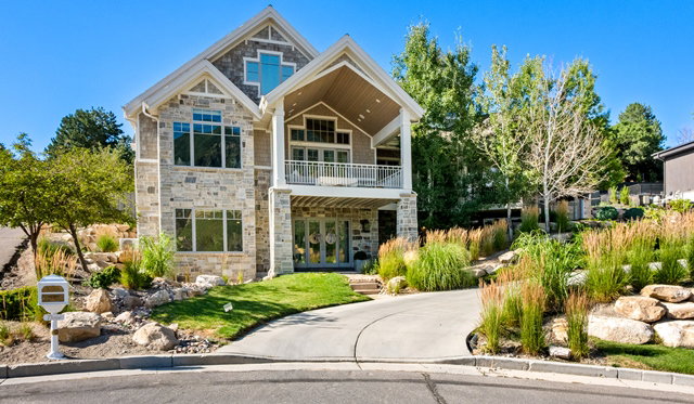 Stone and siding exterior with gabled roofline and multiple window configurations