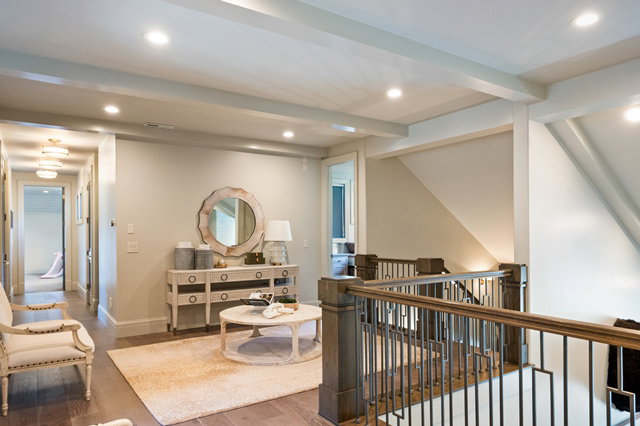 Upper level landing featuring wood-finish flooring, recessed lighting, and a substantial wood and metal staircase railing