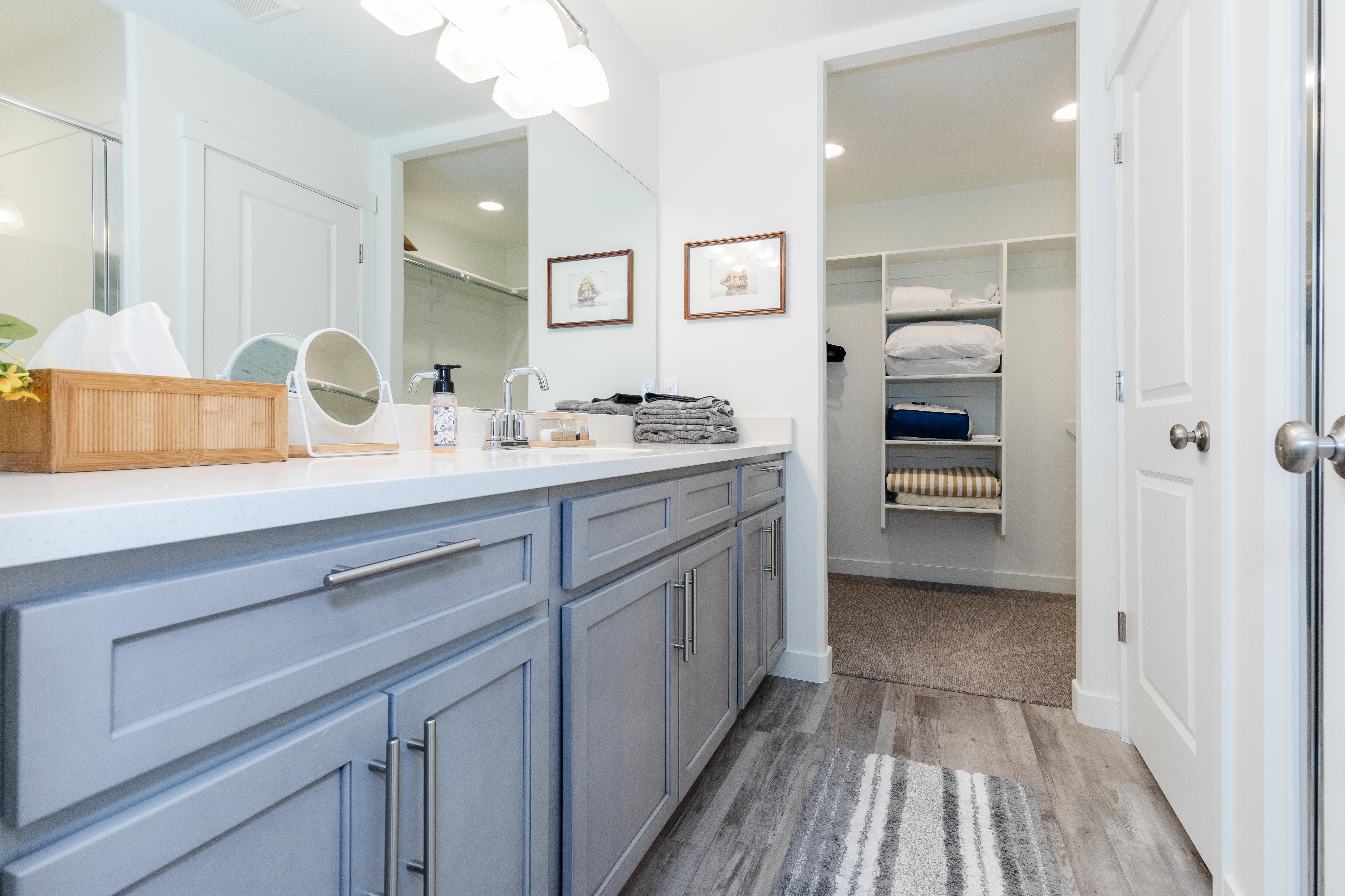 Dual vanity featuring light gray cabinetry with brushed nickel hardware, a light-toned countertop, and undermount sinks