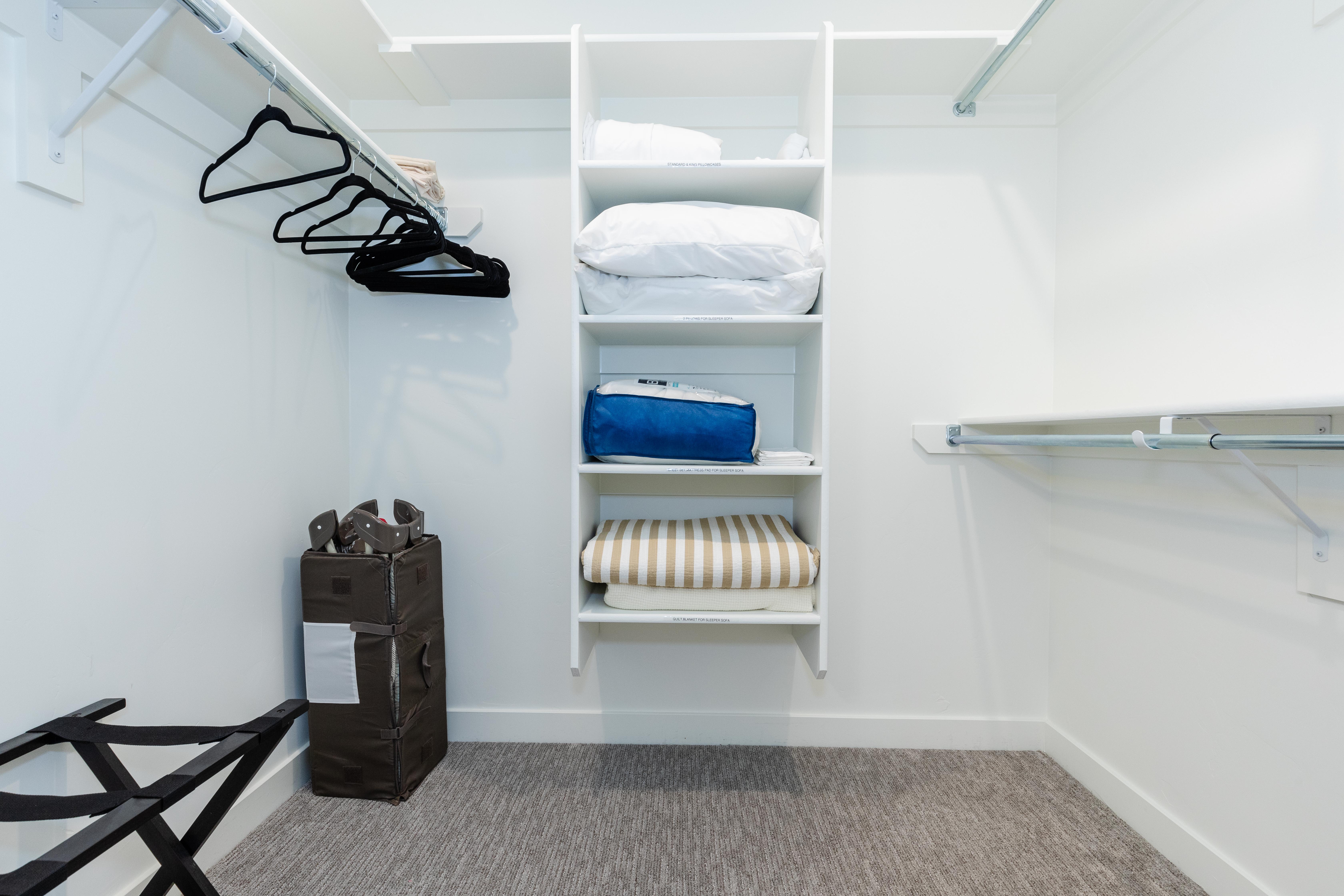 Walk-in closet featuring built-in shelving, white walls, and a light gray carpeted floor