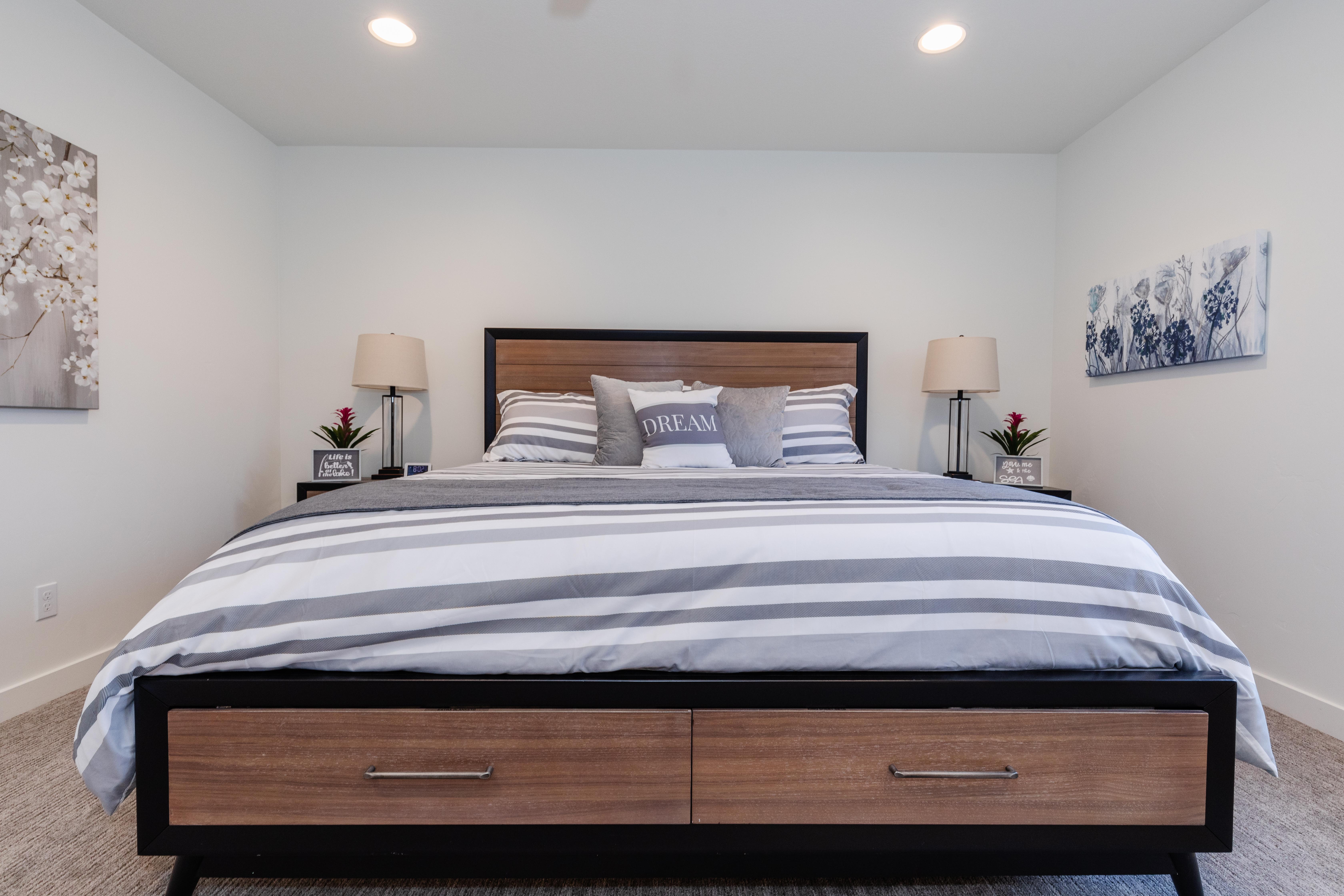 Spacious bedroom featuring light-colored walls, recessed ceiling lighting, and carpet flooring