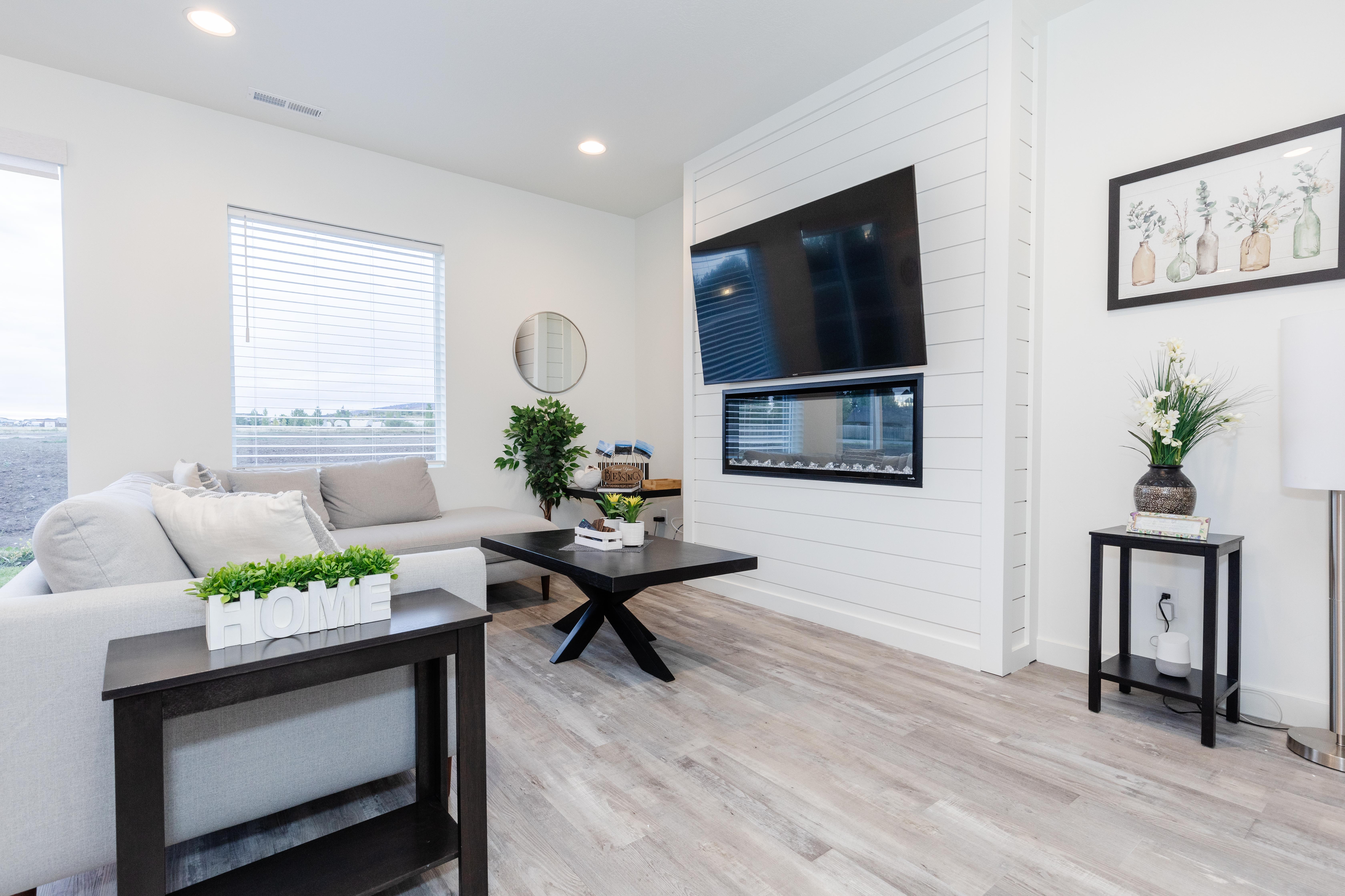 Living area featuring wood-finish flooring, recessed lighting, and a prominent shiplap accent wall with a built-in linear electric fireplace