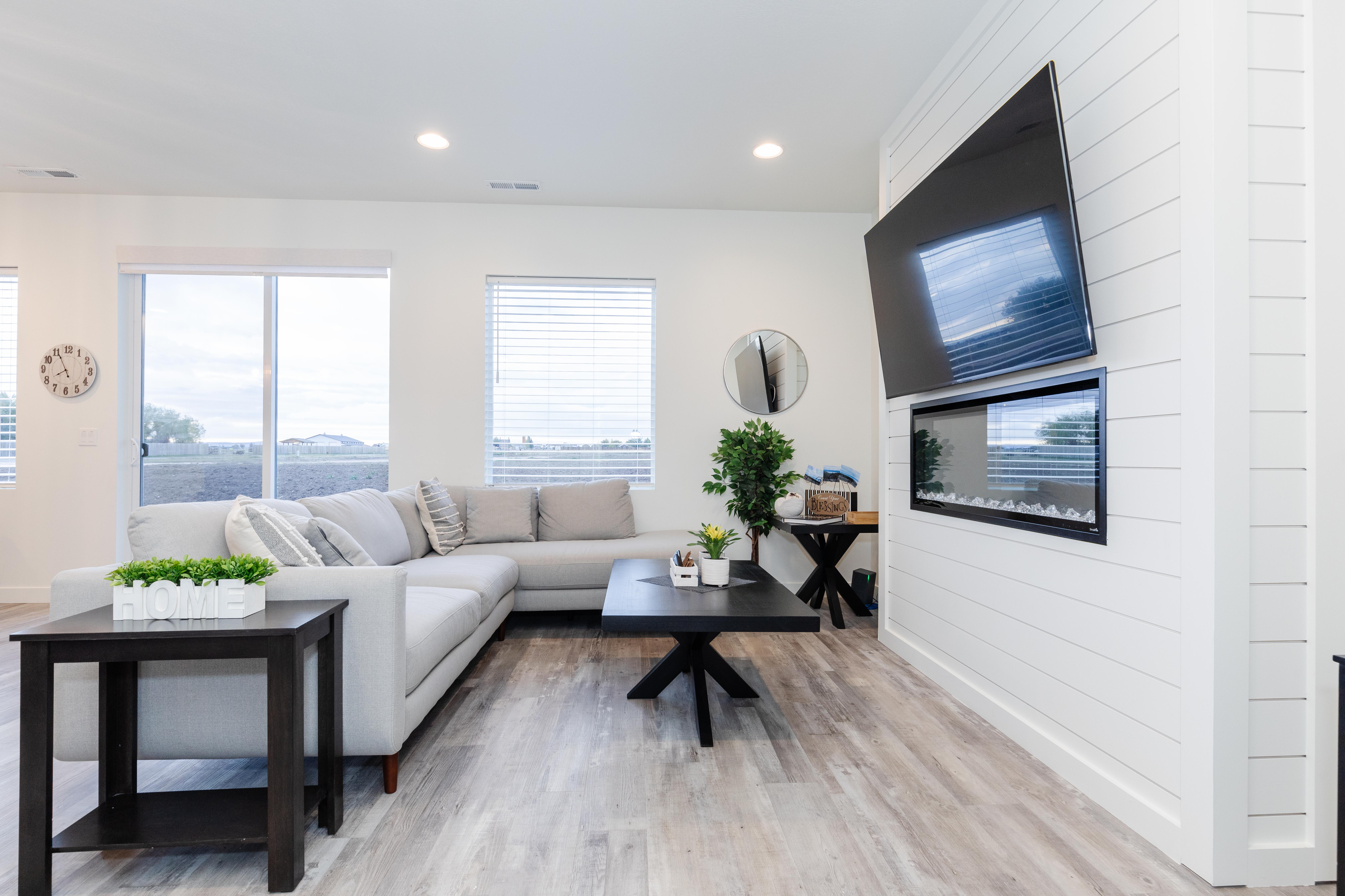 Living area featuring white shiplap accent wall with built-in electric fireplace, wood-finish flooring, recessed lighting, and sliding glass door