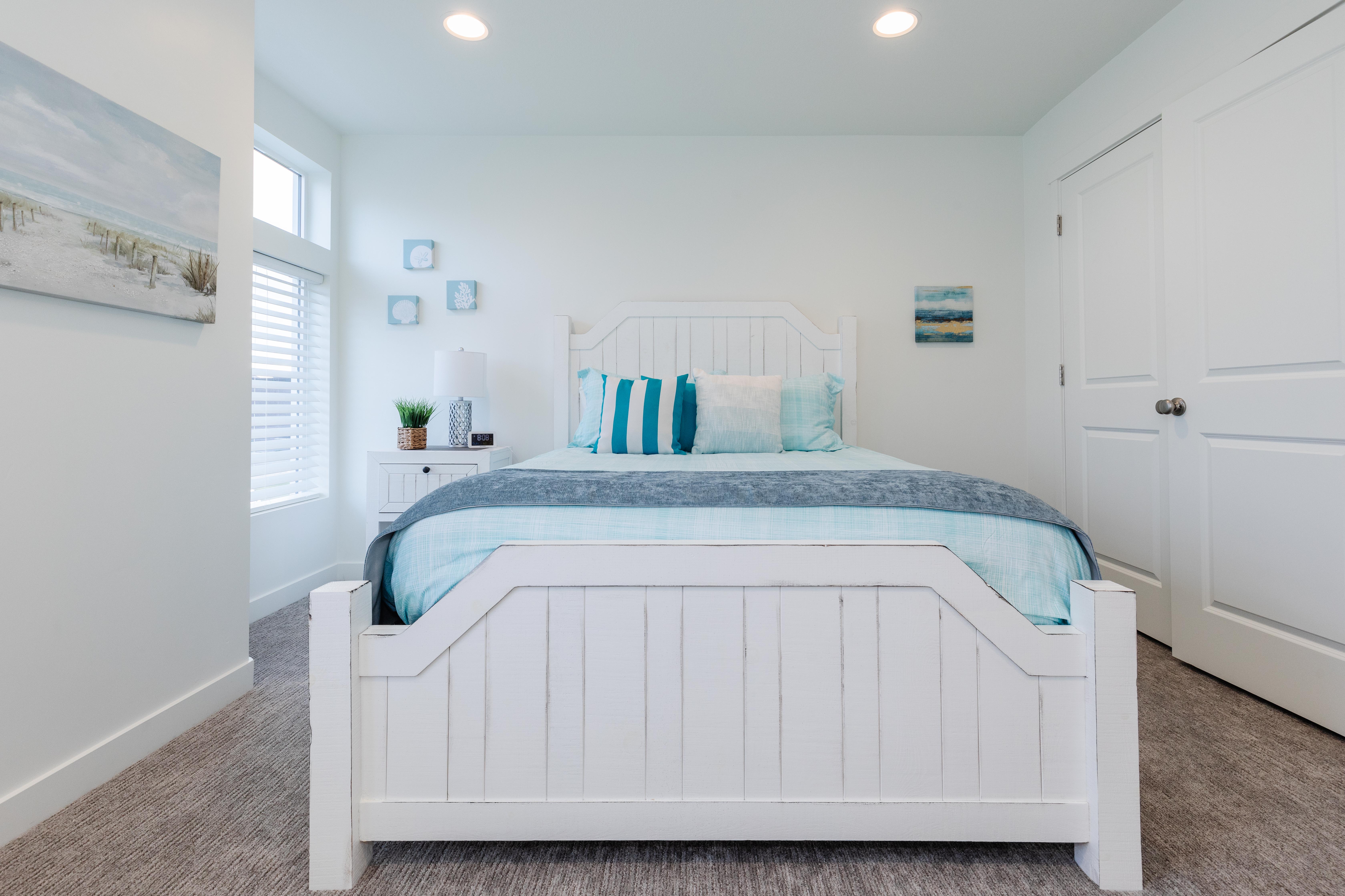 Bedroom featuring a white framed window with blinds, recessed lighting, and neutral carpet flooring