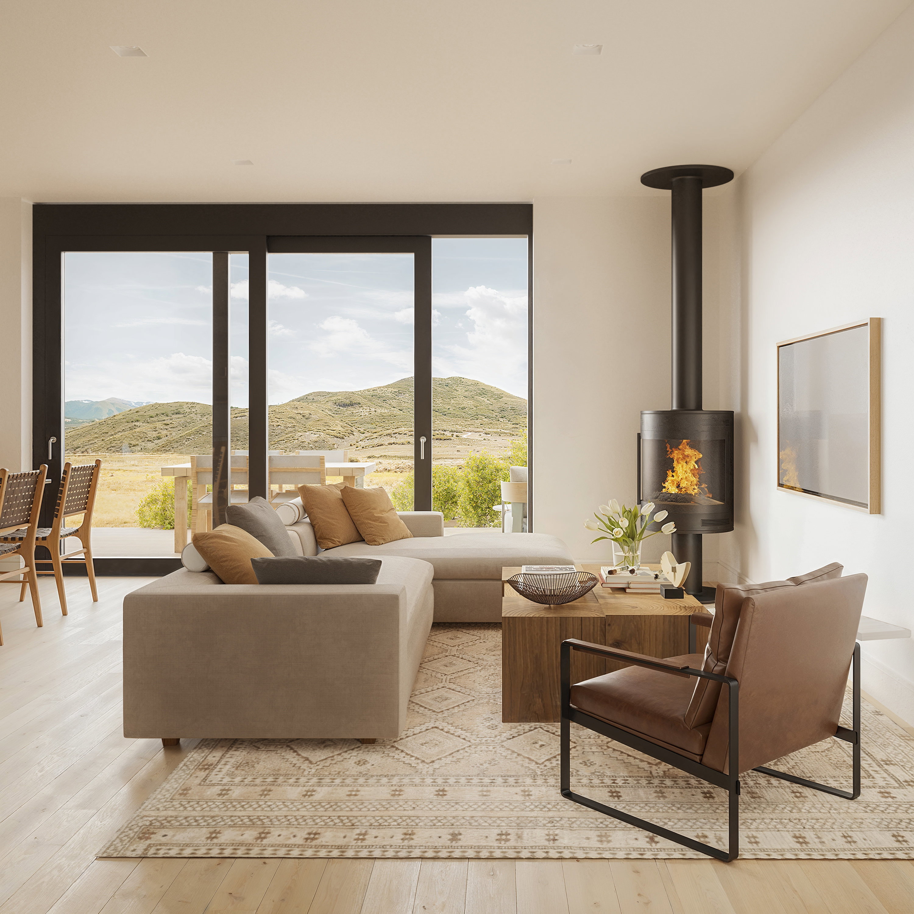 Spacious living area featuring expansive glass sliding doors, a modern freestanding fireplace, recessed lighting, and wood-finish flooring