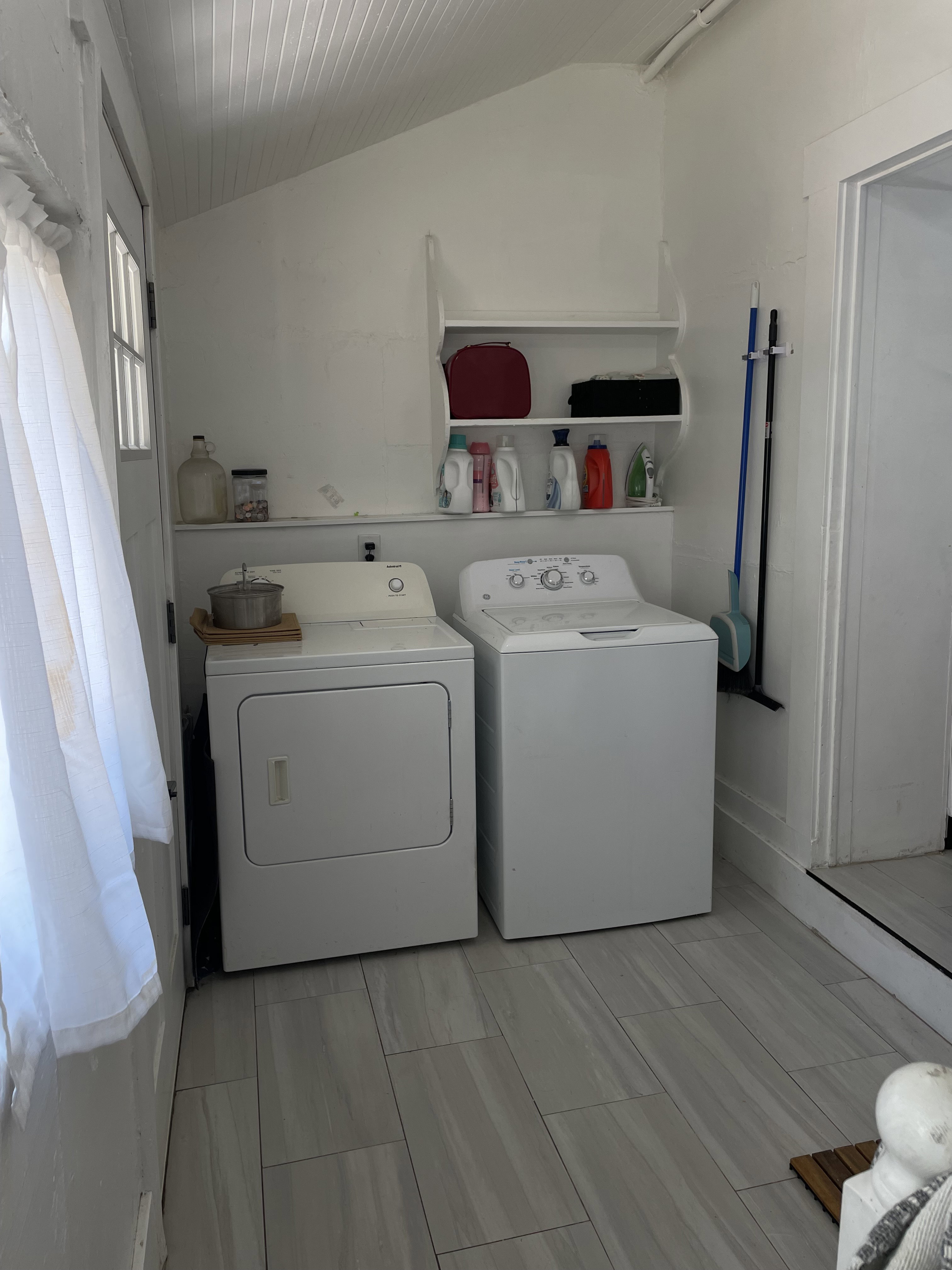 Dedicated laundry area featuring a washer and dryer, tile flooring, white walls, and built-in shelving