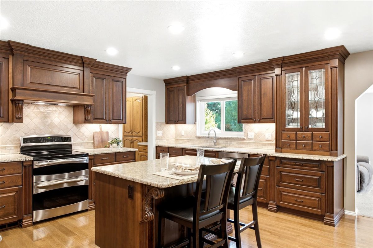 Completely remodeled and expanded custom kitchen with hardwood cabinets and thoughtfully designed details to streamline functionality. Lighted built-in china cabinet