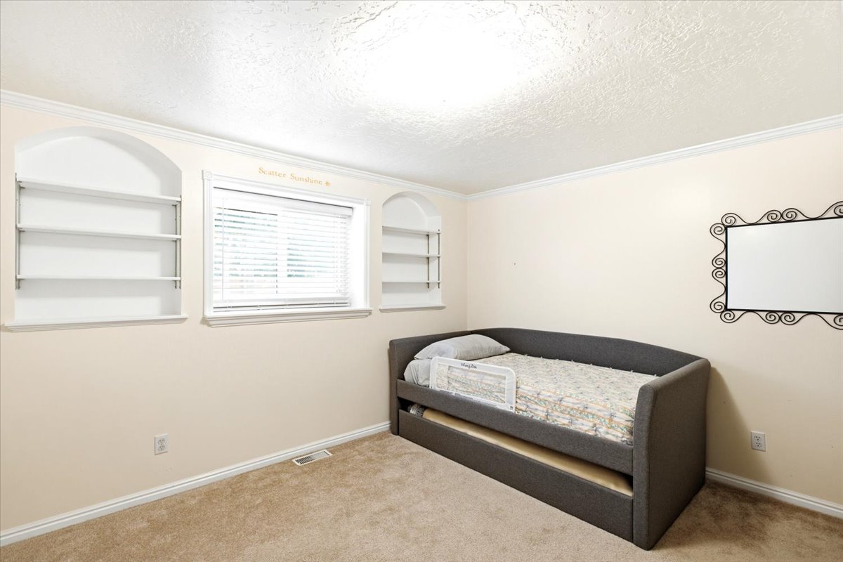 Bedroom 2 with built-in book shelves. Daylight window