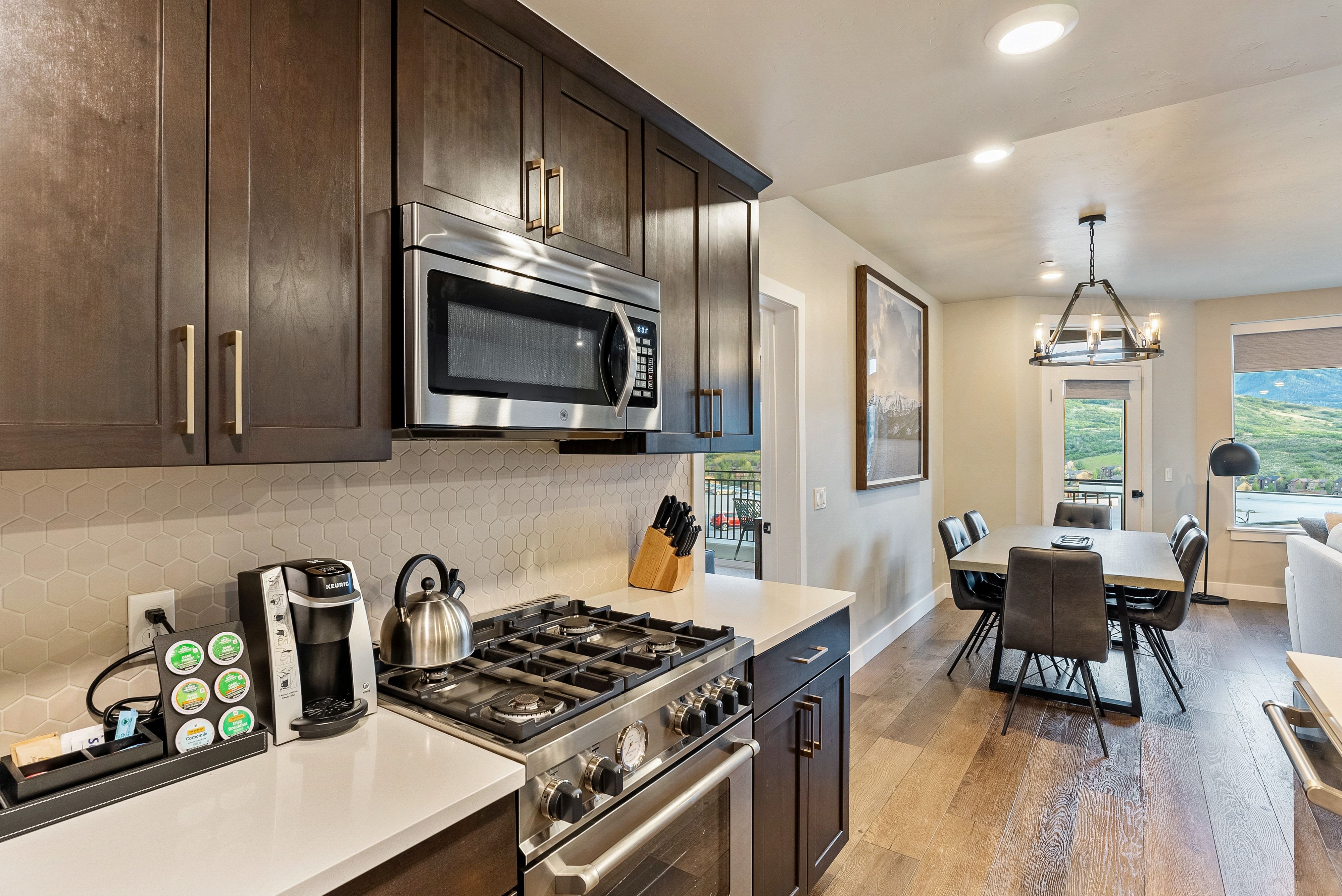 Kitchen featuring wood-finish cabinetry, stainless steel appliances, and hexagon tile backsplash