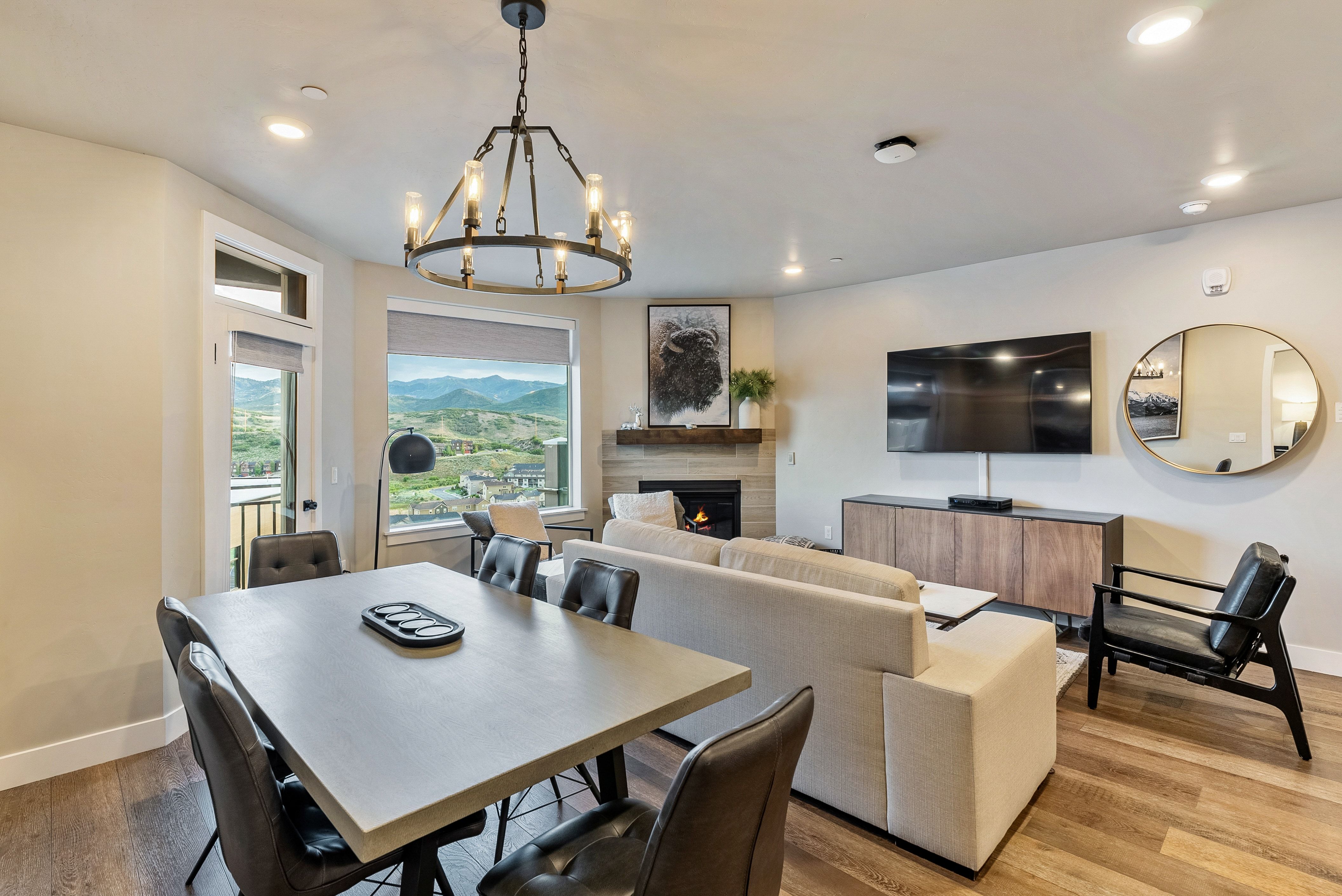 Open-concept living area featuring wood-finish flooring, recessed lighting, and a modern chandelier