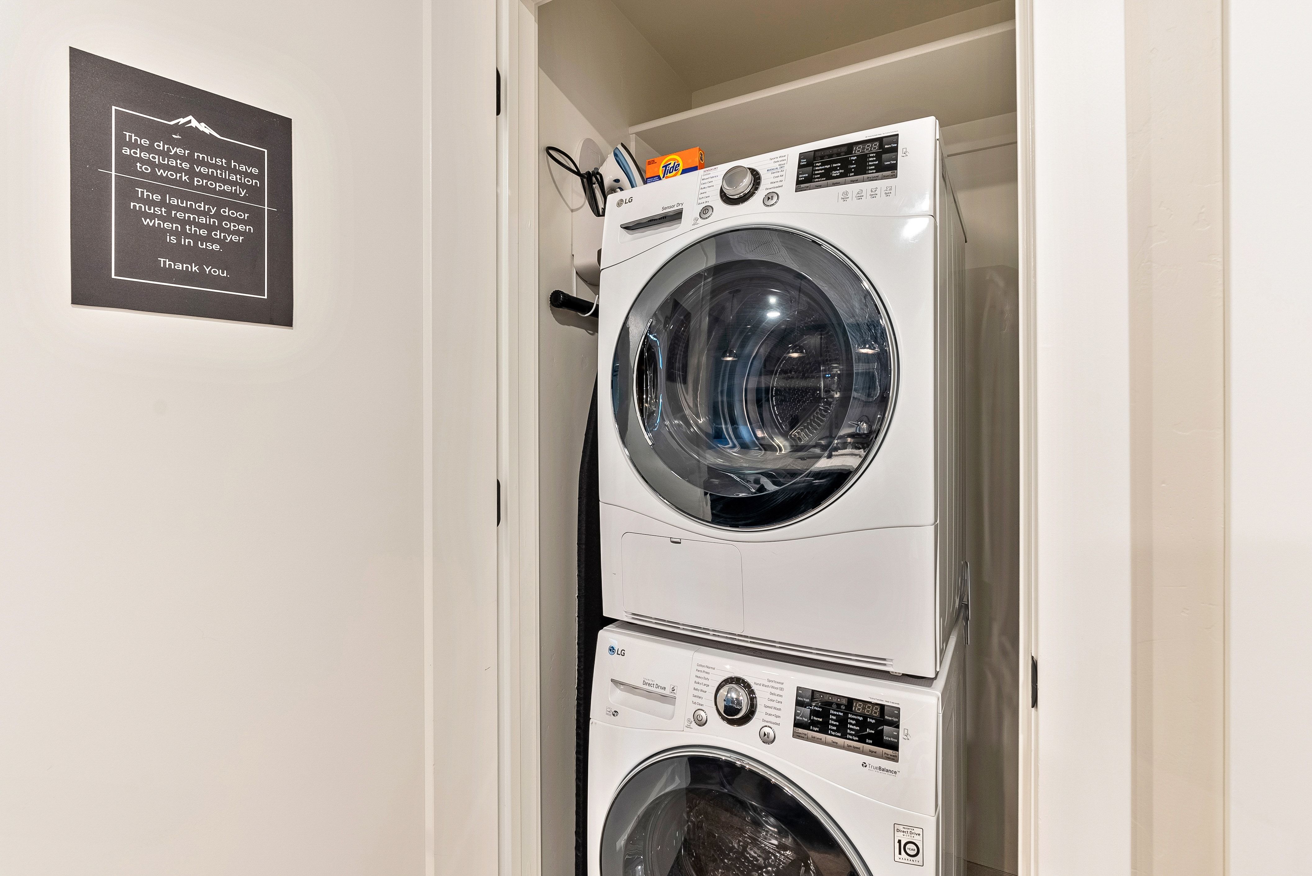 Dedicated laundry closet featuring a stacked washer and dryer unit