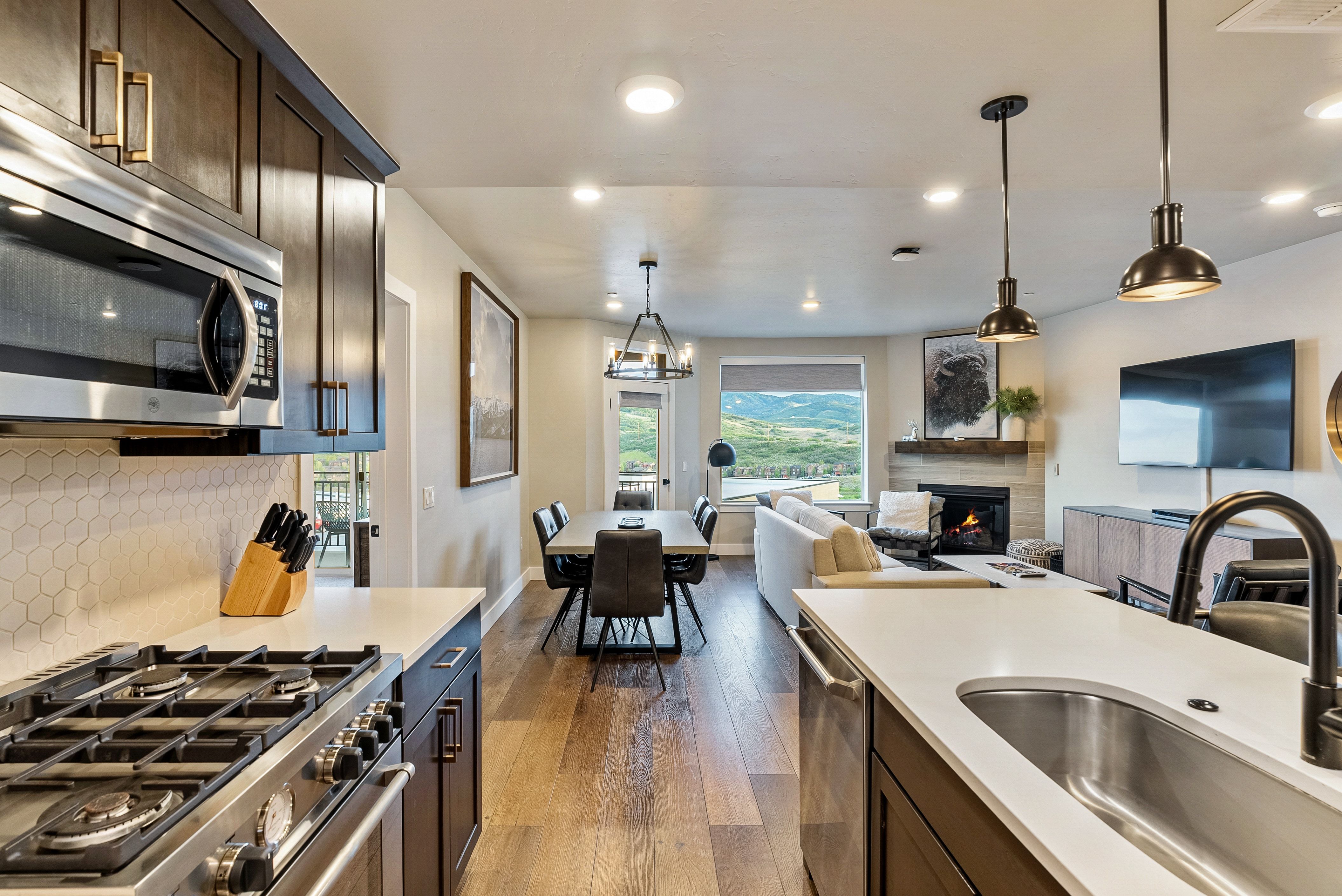 Contemporary kitchen featuring stainless steel appliances, dark wood-finish cabinetry, and solid surface countertops