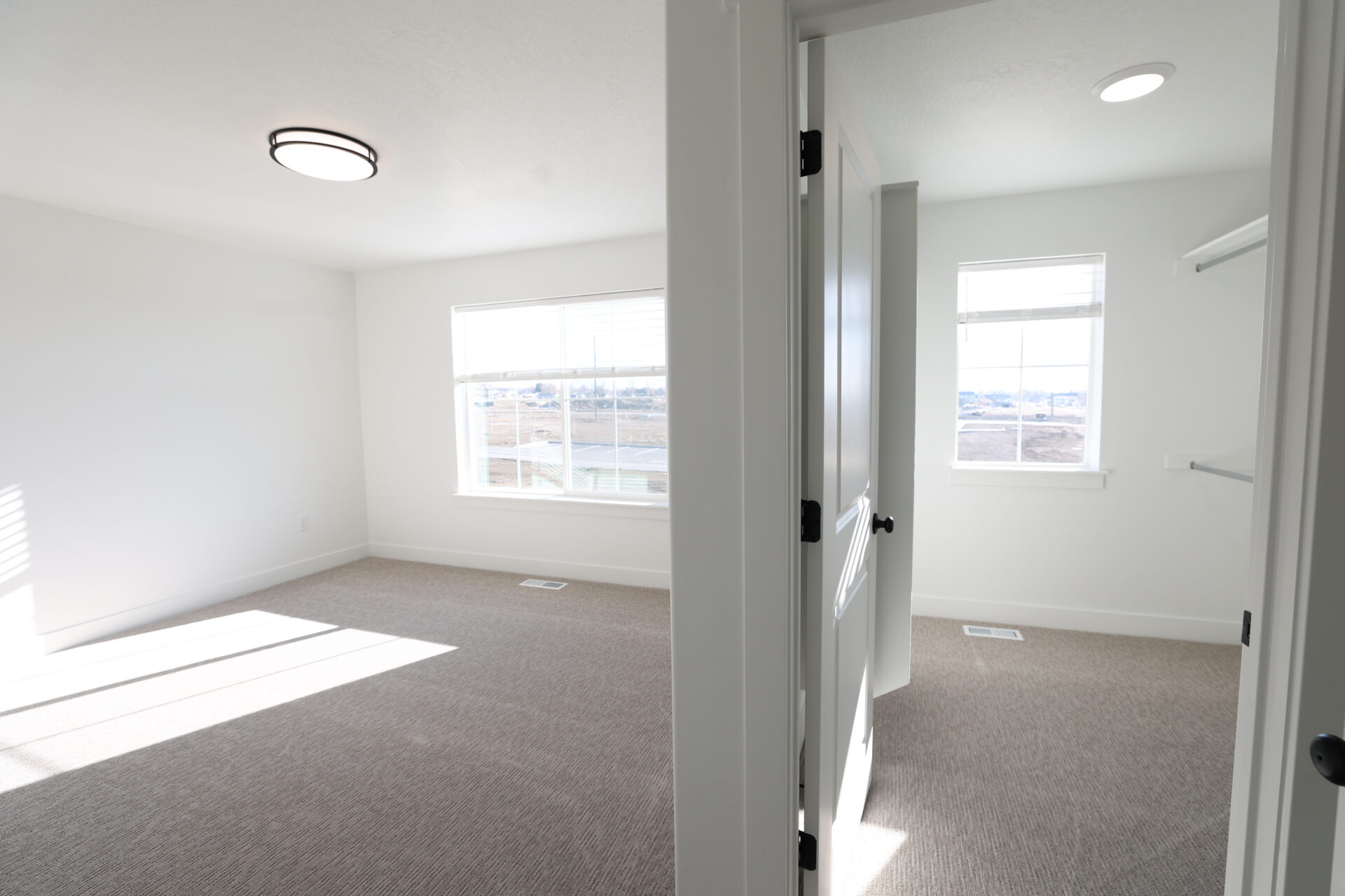 Spacious room with light neutral carpet and white walls