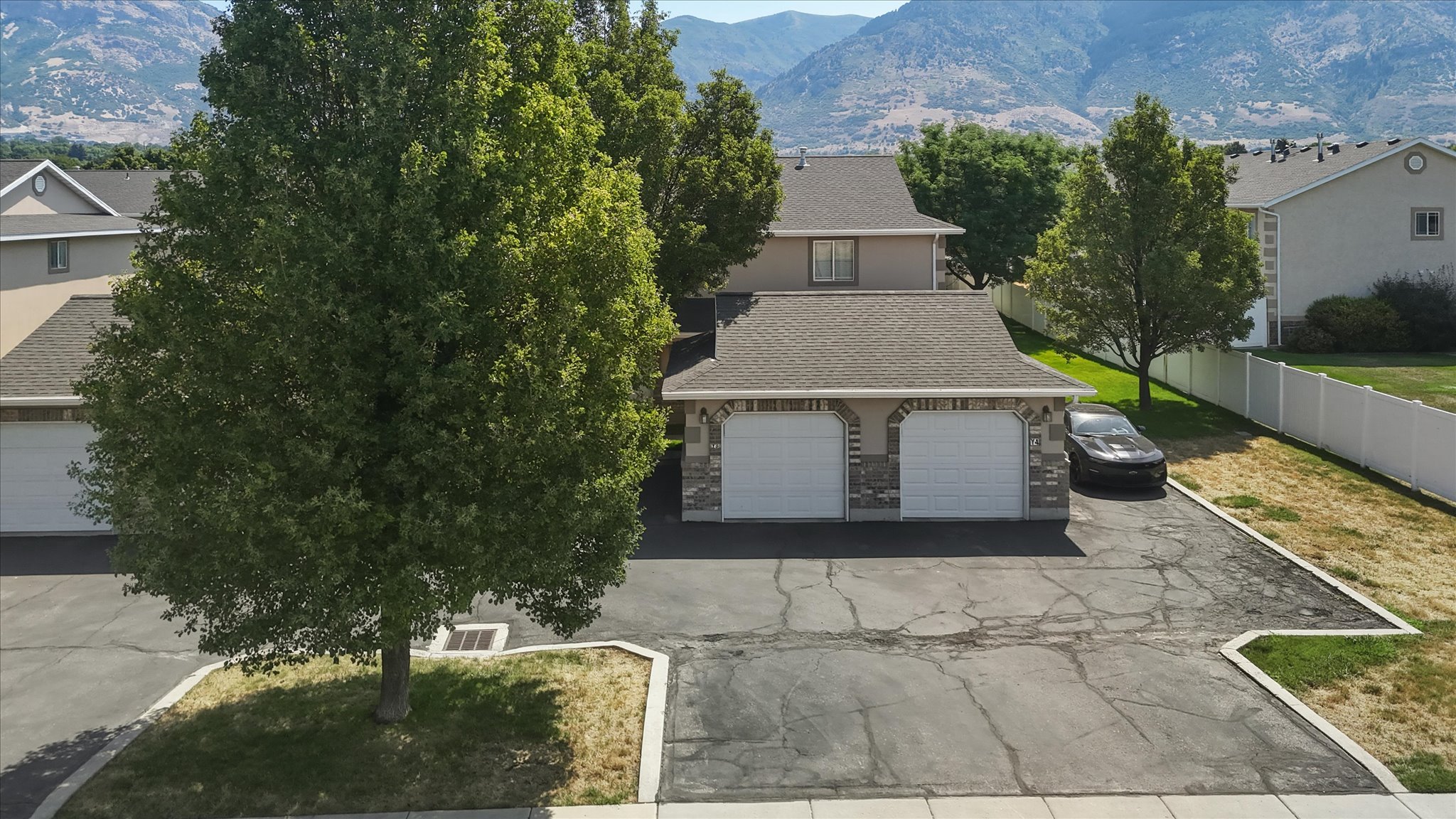Two-car garage with stone veneer accents and a paved driveway