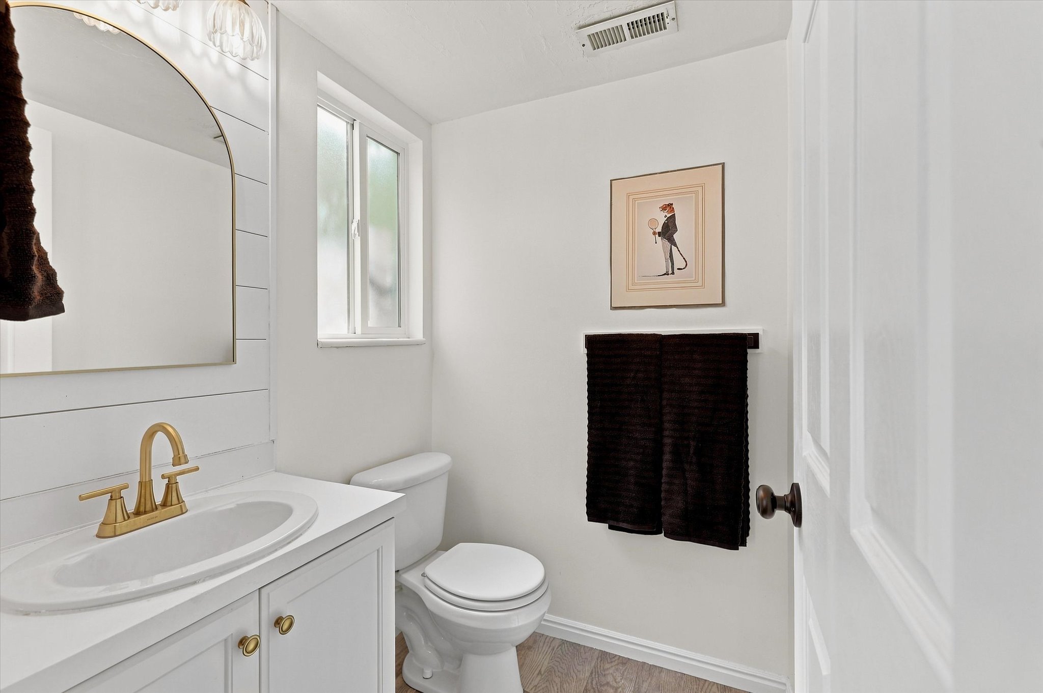 White vanity with brass hardware and gold-finish faucet