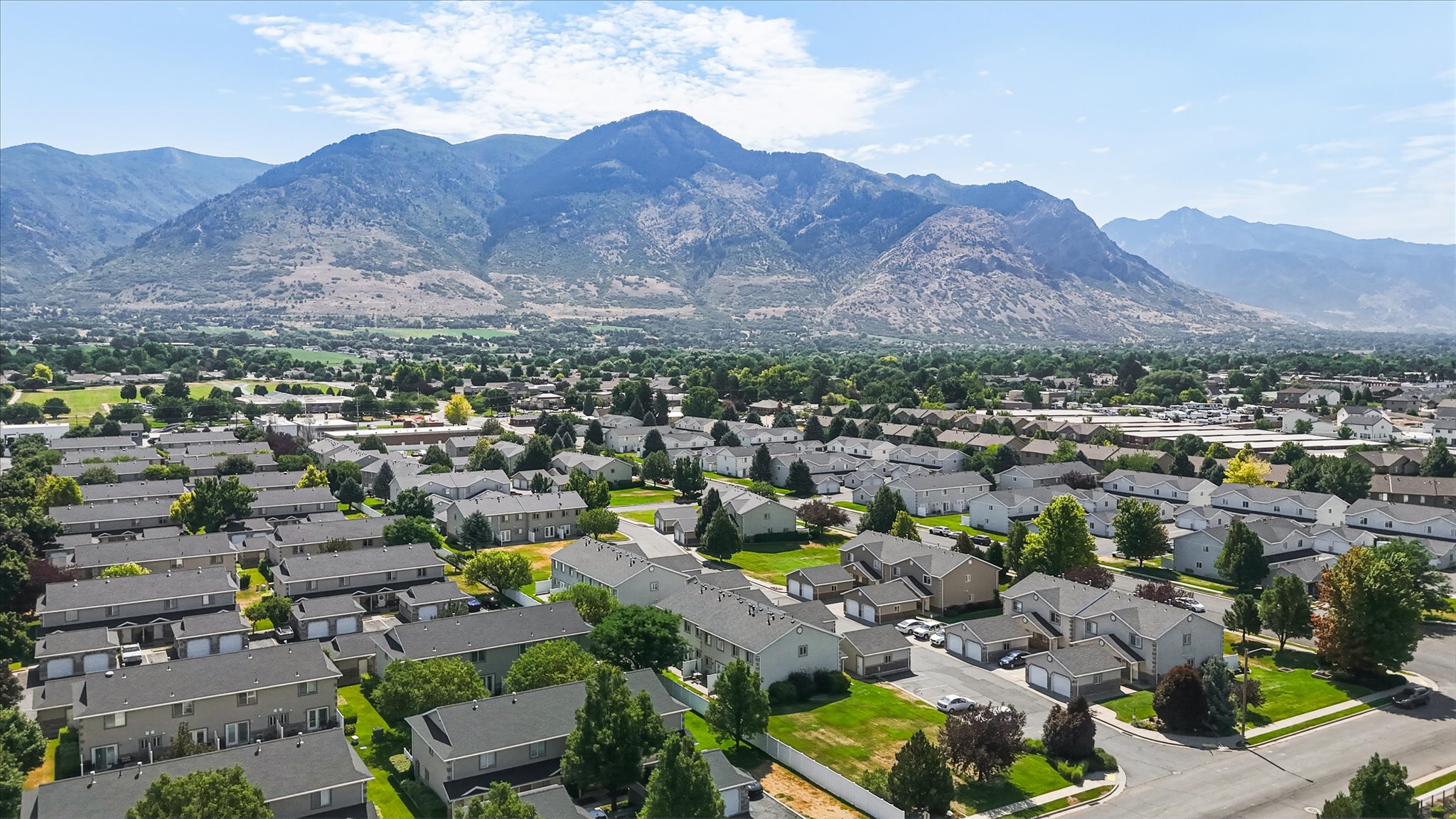 Community residences with mountain backdrop, offering green spaces and paved roadways