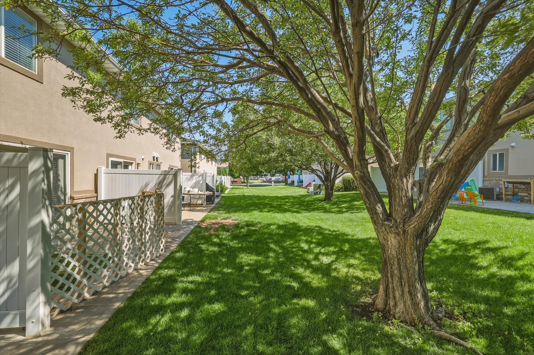 Expansive green lawn featuring mature trees