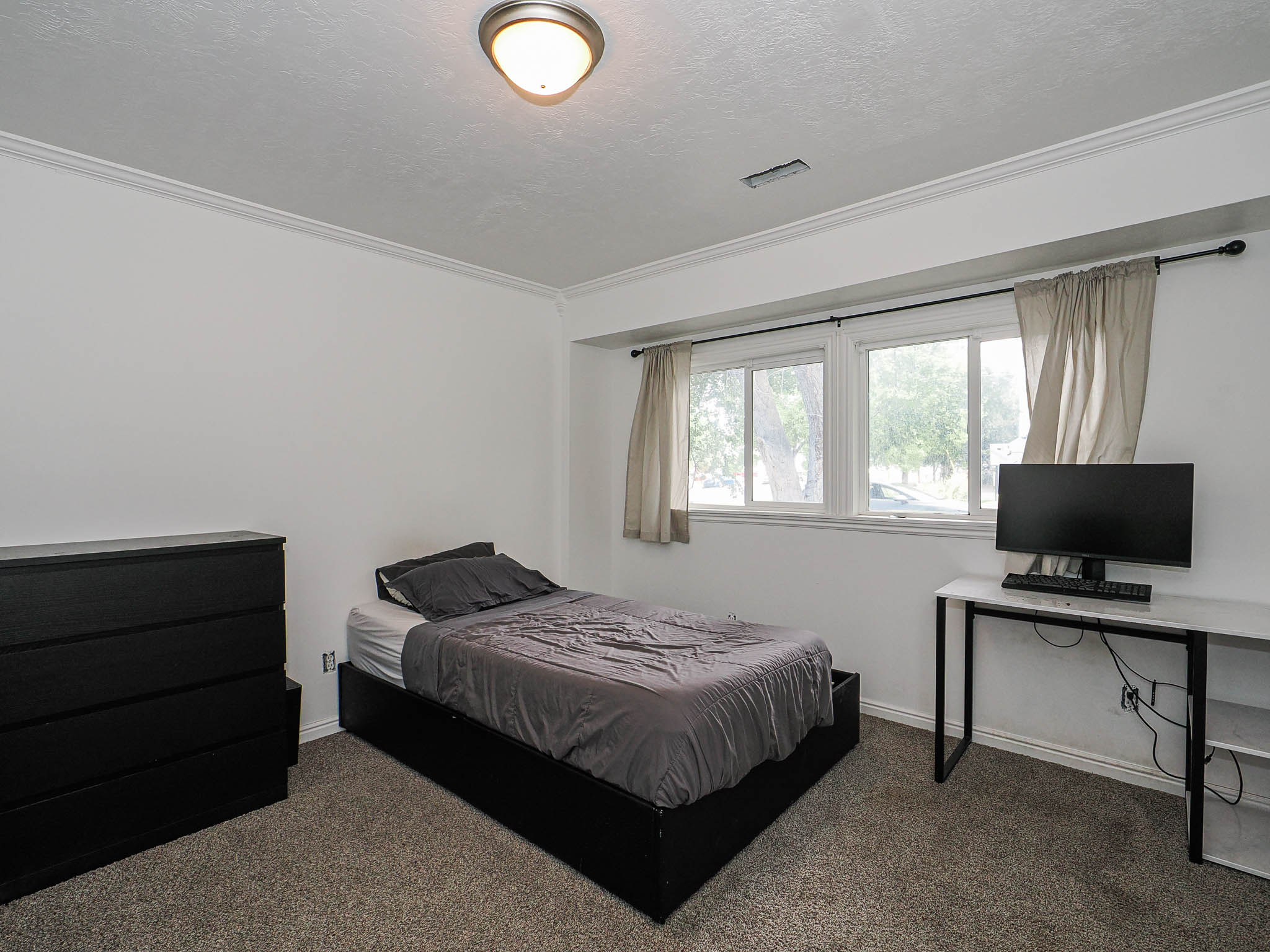 Room featuring white walls, crown molding, and a dual-pane window with white trim