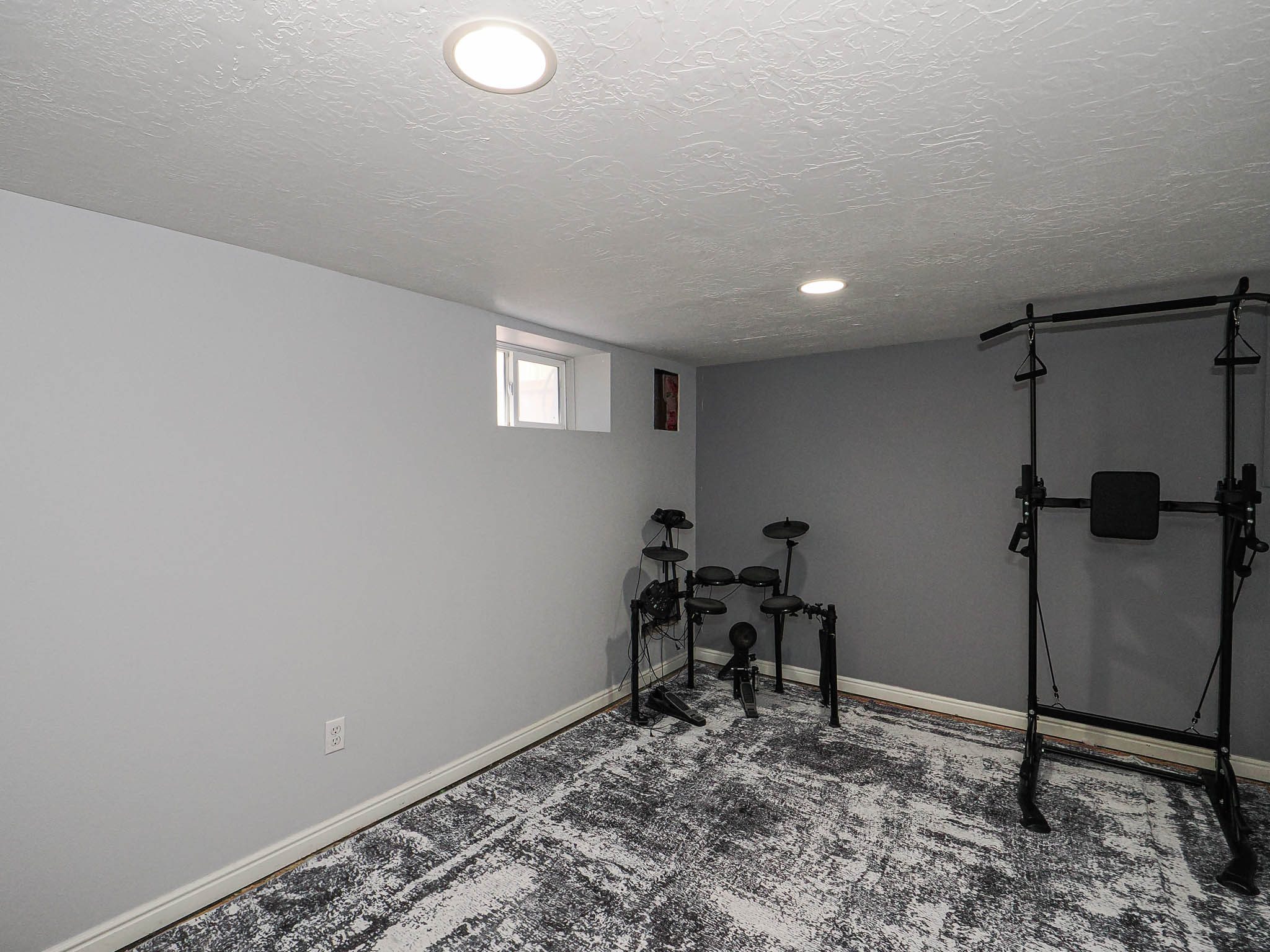 Room featuring light grey painted walls and a dark grey accent wall
