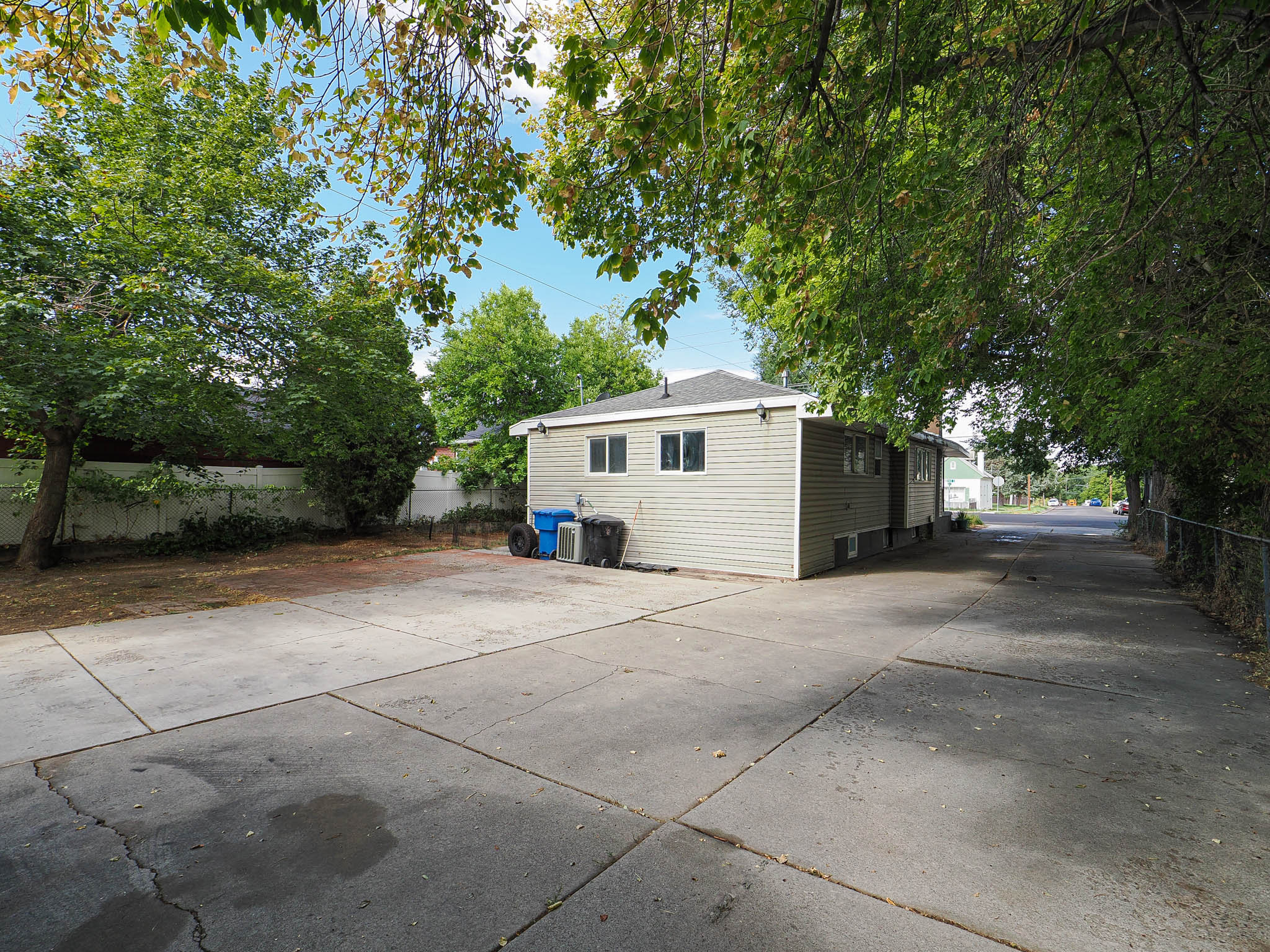 Expansive concrete driveway beside a light-colored siding structure with multiple windows