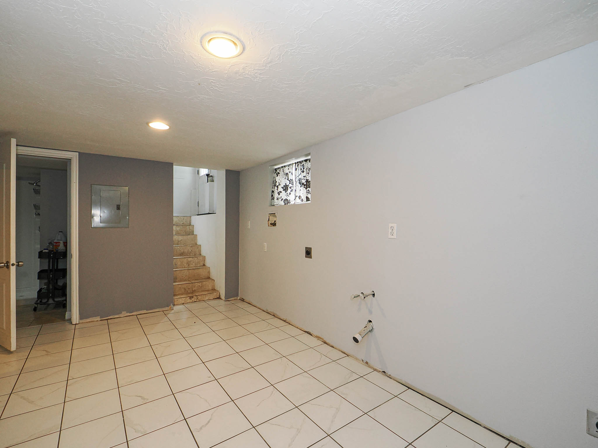 Spacious room featuring tile flooring, neutral wall tones, and recessed lighting