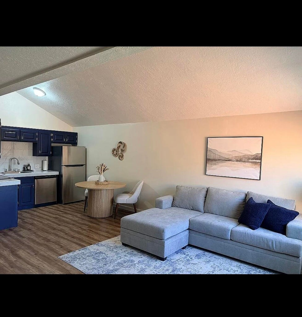 Vaulted ceilings accent an open-concept living area with wood-finish flooring
