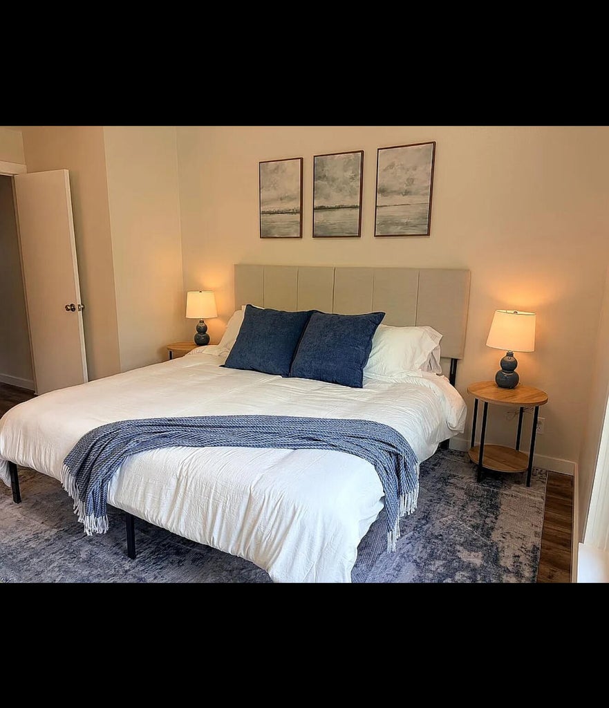 Bedroom featuring light-toned wall paint and wood-finish flooring