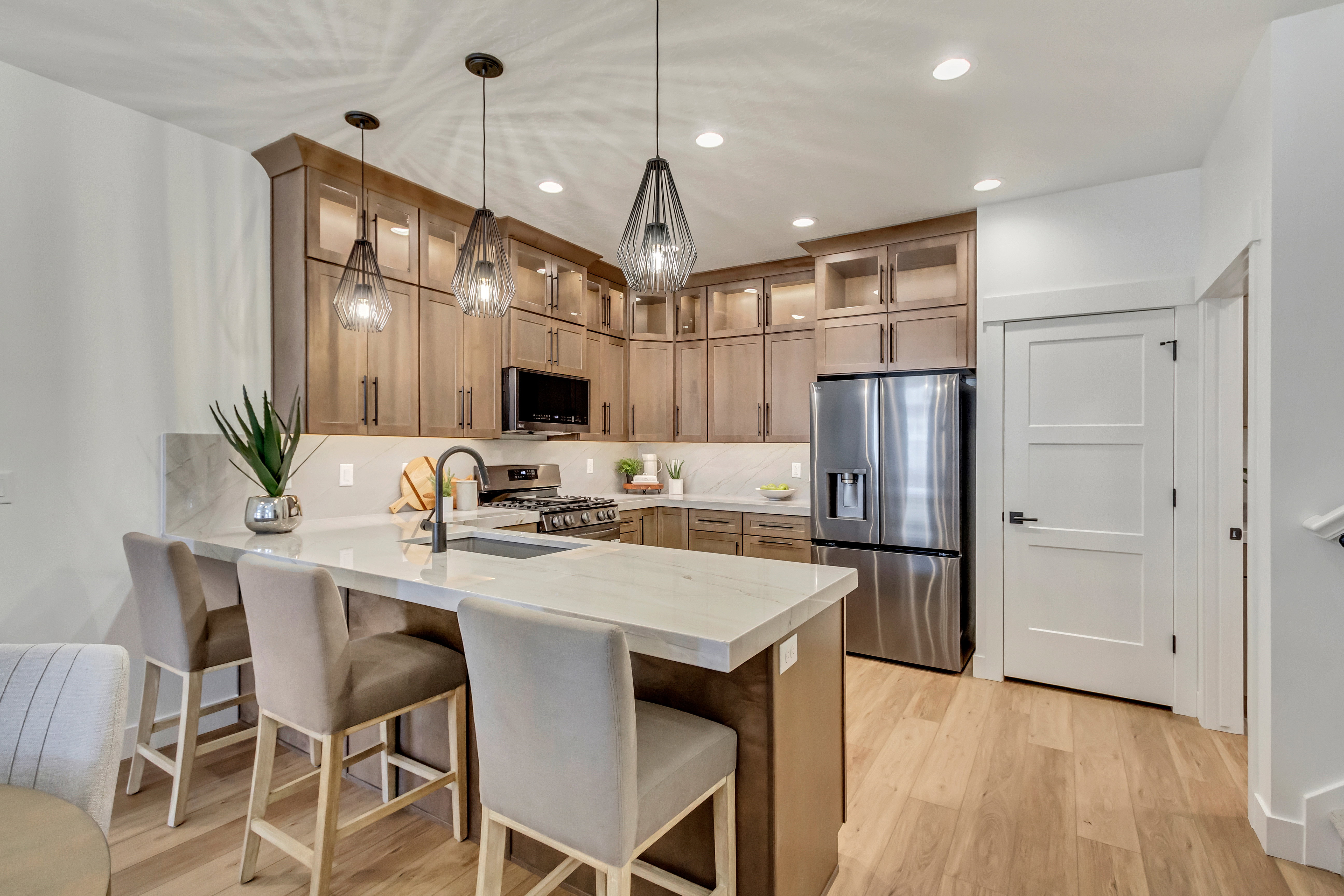 Contemporary kitchen with light wood-finish flooring and recessed lighting