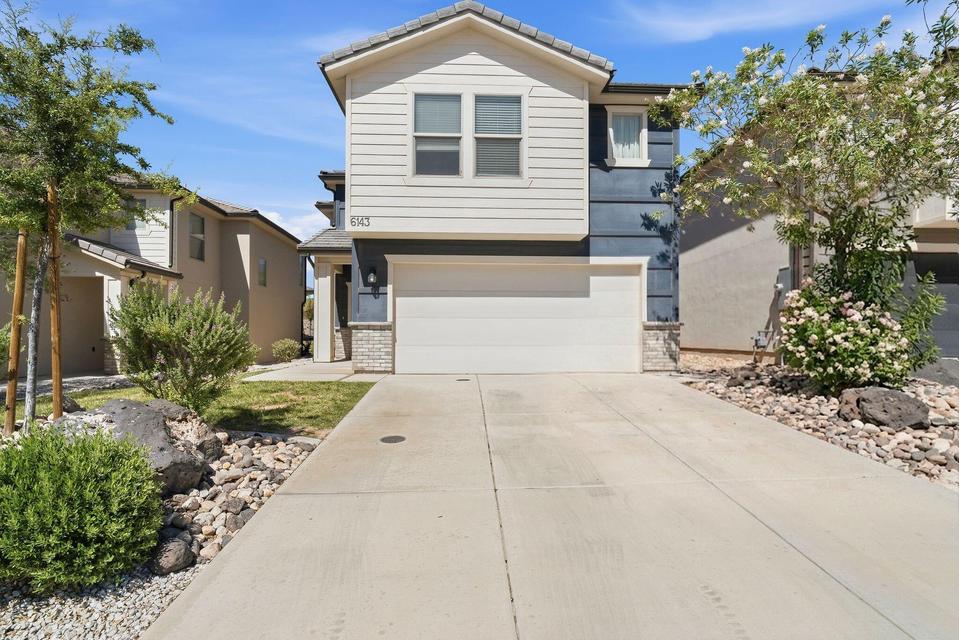 Contemporary two-story exterior featuring a two-car garage, durable hardie board siding, and stone accents