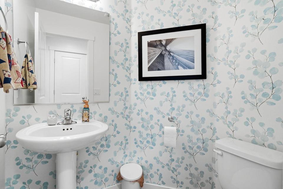 Pedestal sink with chrome faucet and framed mirror