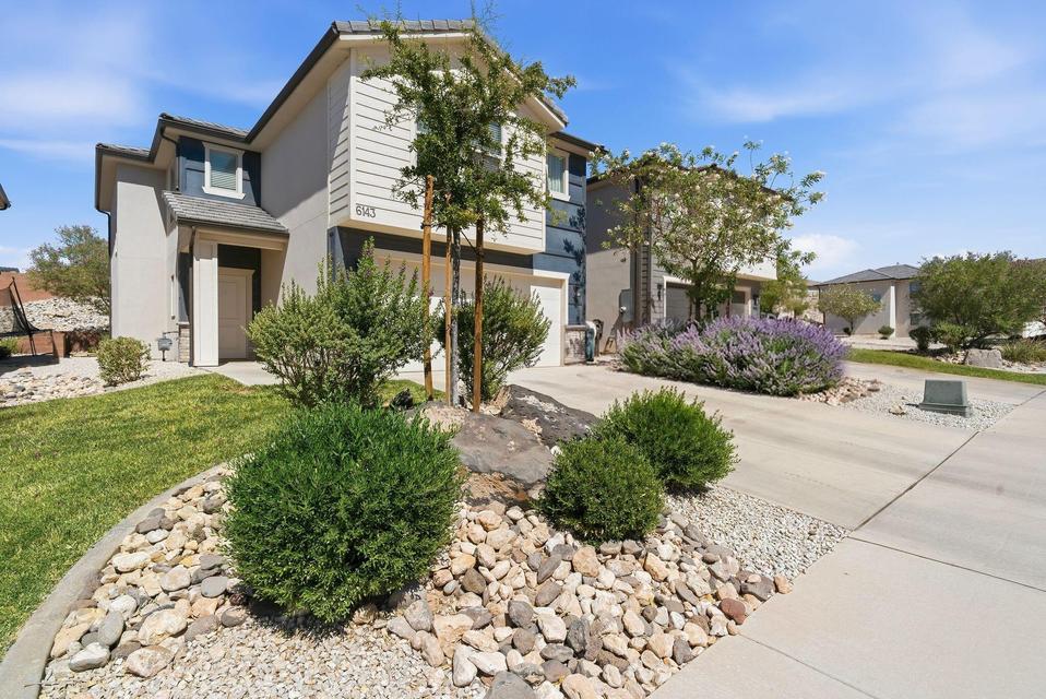 Contemporary multi-story residence featuring a two-tone exterior, a covered entryway, and a prominent garage