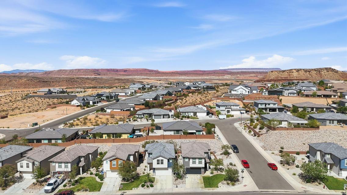 Residential development featuring varied architectural styles and desert landscaping, with distant red rock formations under a clear sky