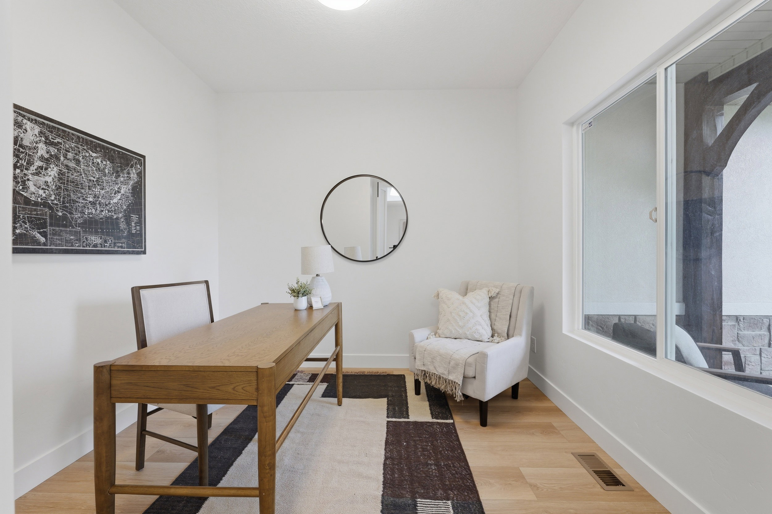 Dedicated space featuring light wood-finish flooring, crisp white walls, a single window, and a ceiling-mounted light fixture