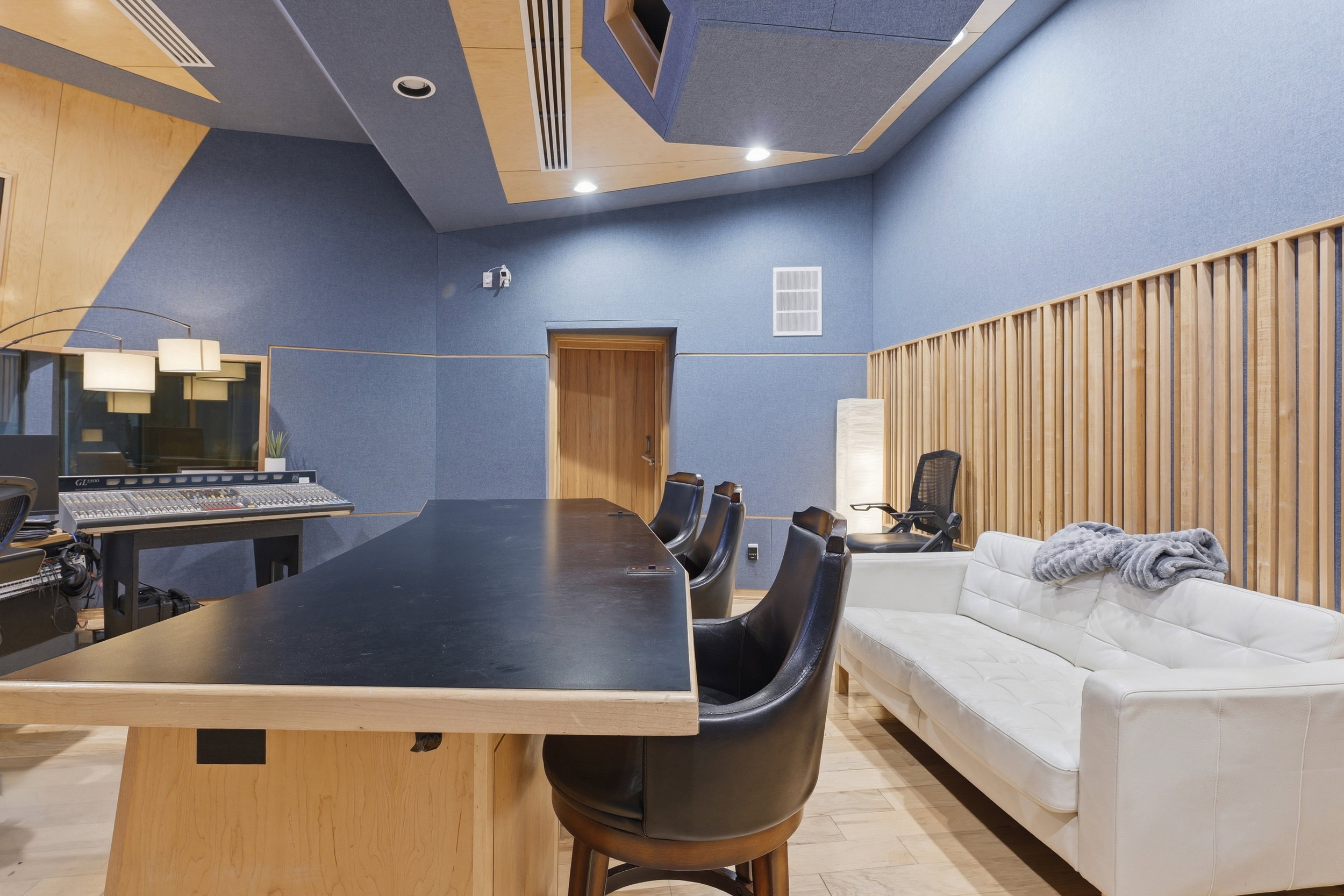 Dedicated studio space featuring acoustic paneling, wood slat wall details, recessed lighting, and a solid wood door